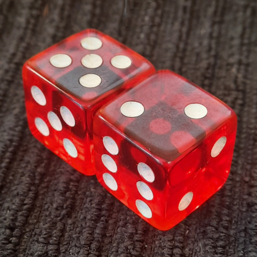 A pair of six-sided dice, red with white pips on a black background.  The faces have nonstandard pip counts, suggesting incompetence or ill intent.